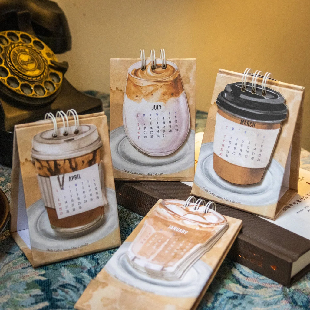 Coffee themed mini desk calendar for 2025 showing four different model designs on a desk.