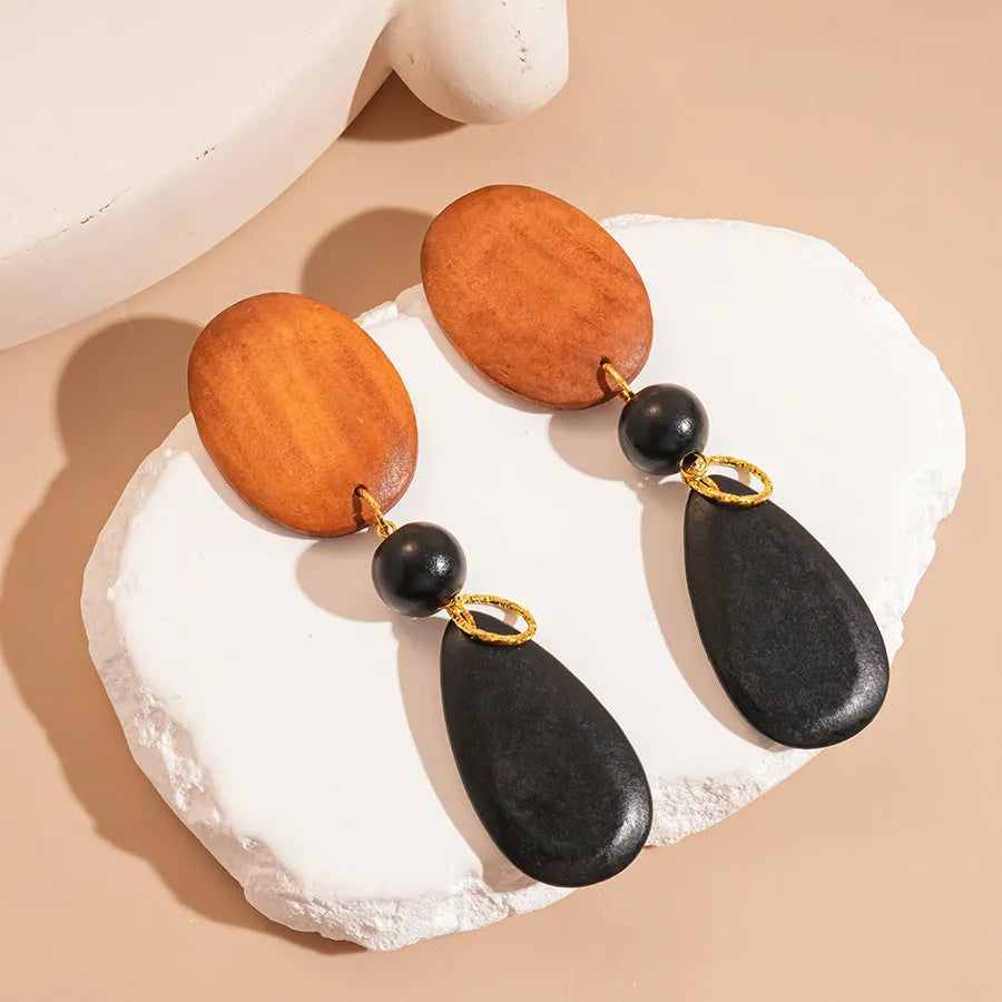 Women's brown-black wooden elliptical earrings with silver needle detailing