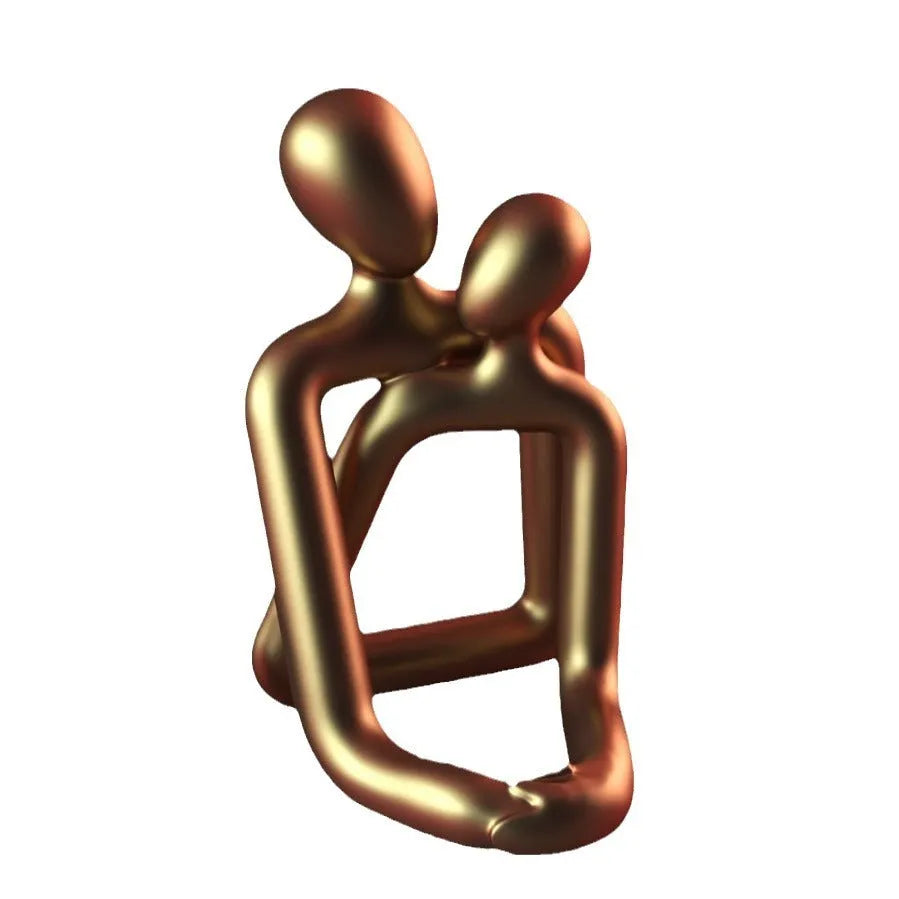 Modern couple resin statue in milky white or gold on a wooden surface.