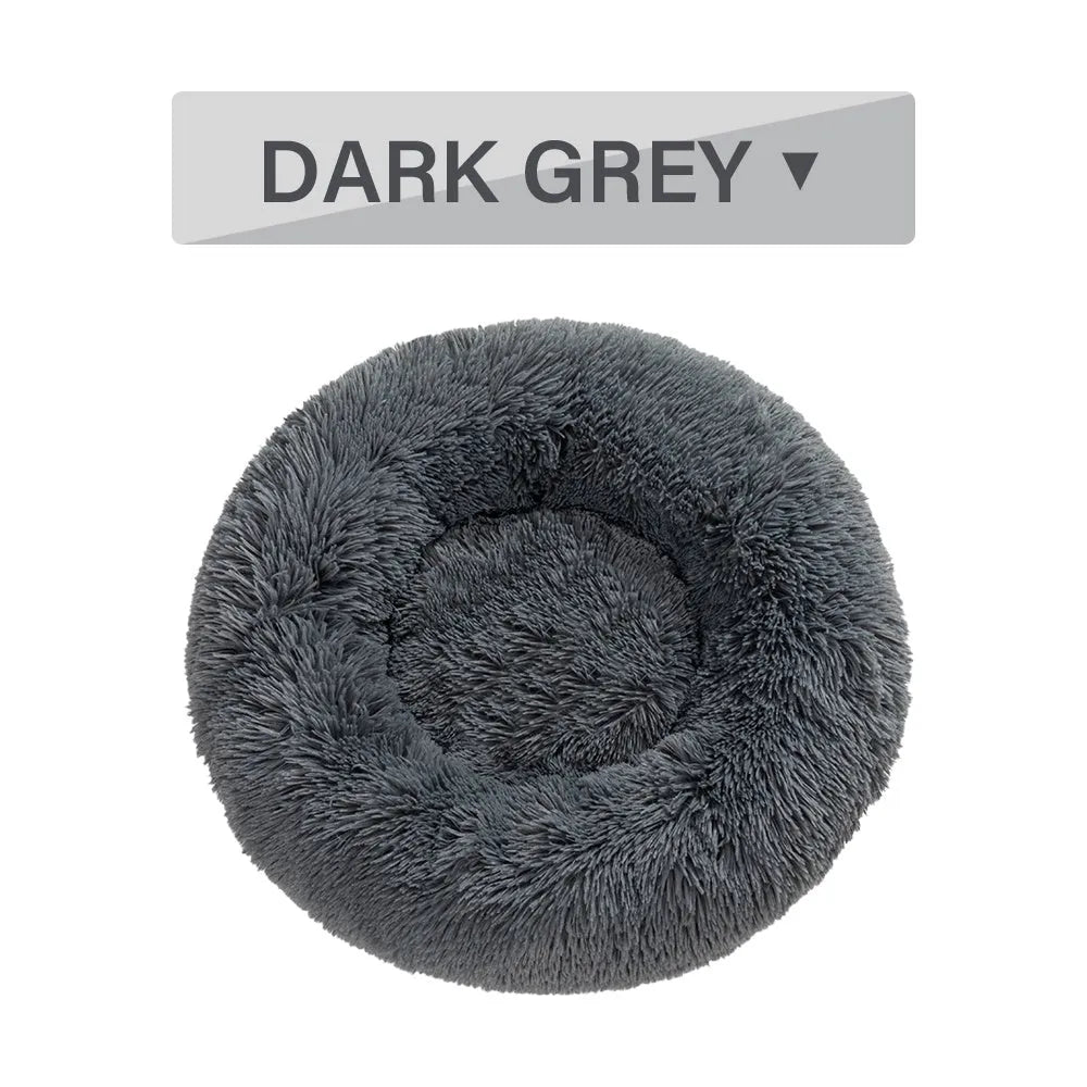 A round donut-shaped dog bed with a raised plush rim, shown in a light grey colour.