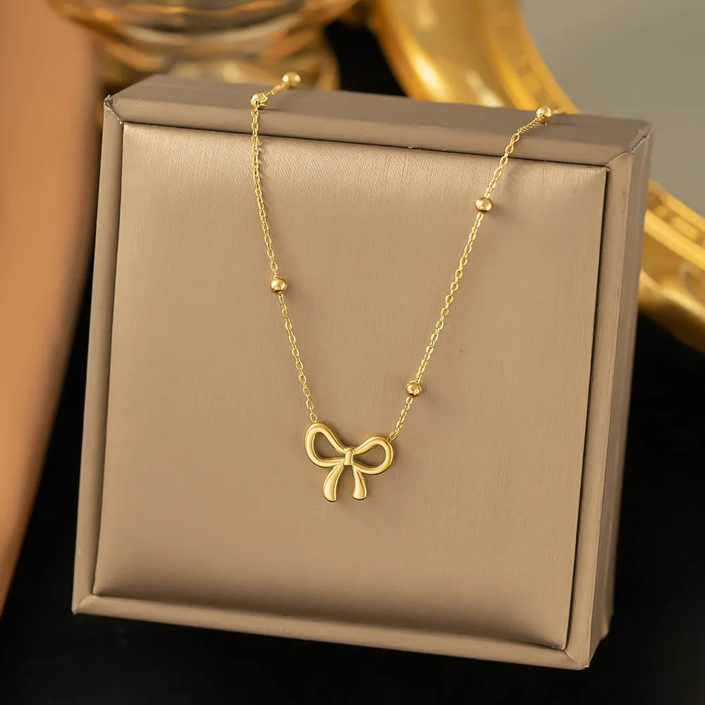 Gold-colour titanium steel necklace with a bow pendant on an adjustable chain