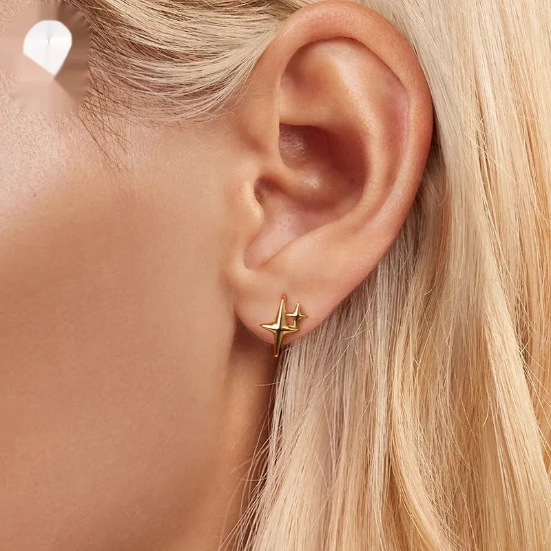 Minimalist star-shaped silver ear clips with oxidation finish and contemporary design details