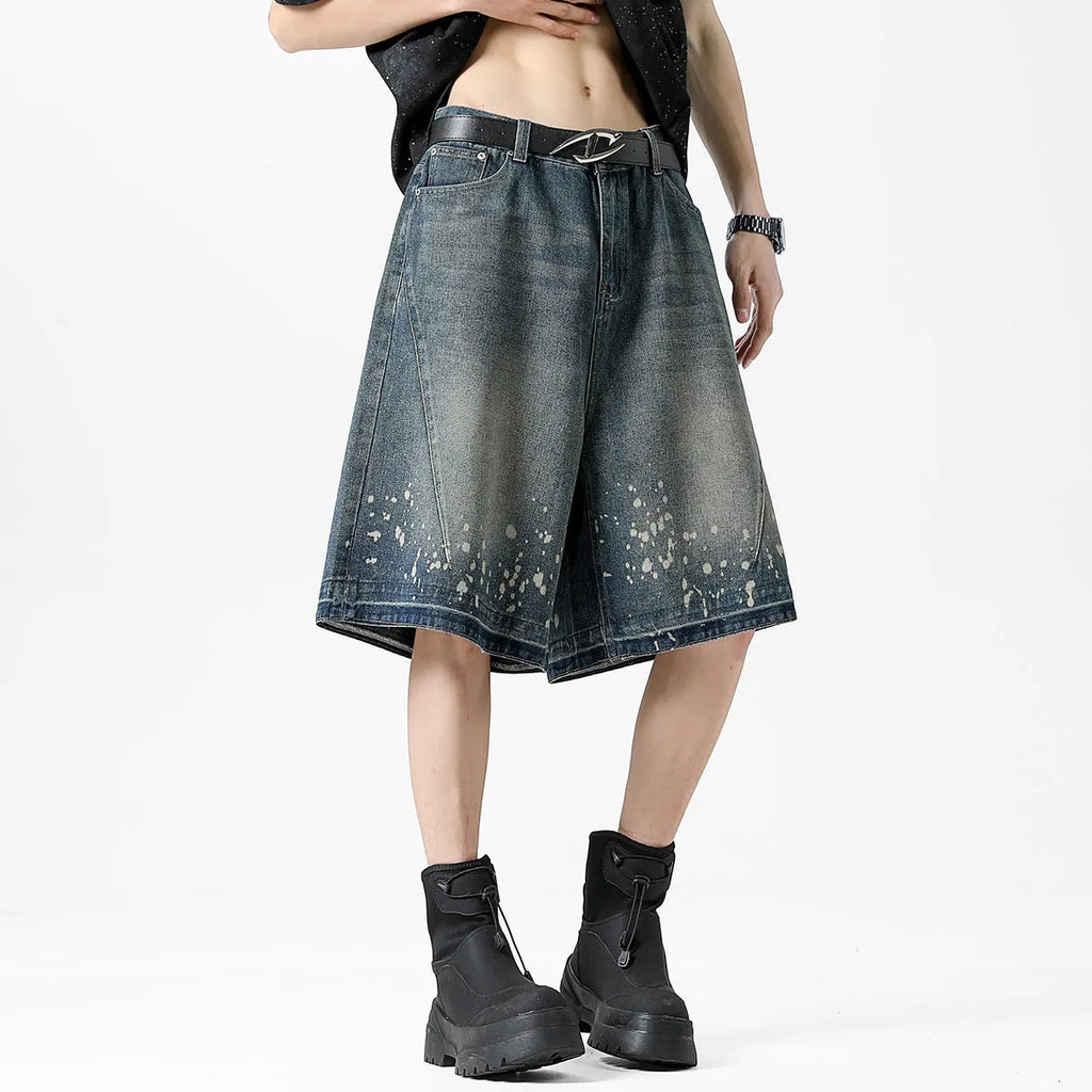 Man wearing retro blue washed denim shorts with ripped details and a straight-leg cut.