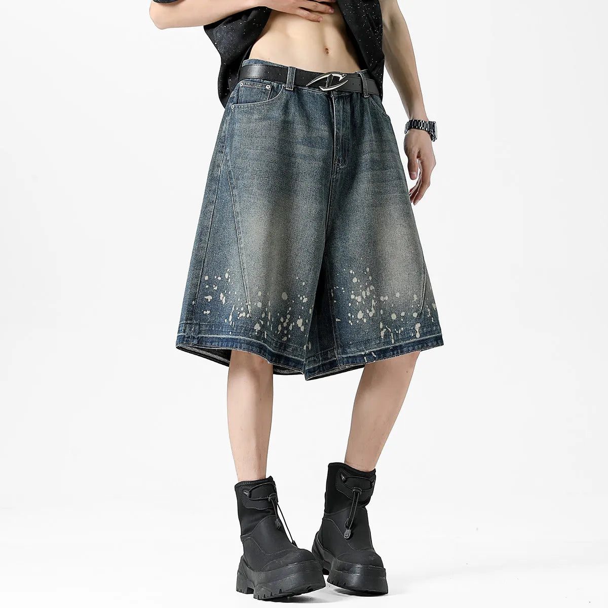 Man wearing retro blue washed denim shorts with ripped details and a straight-leg cut.