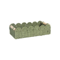 A woven paper storage basket in a neutral colour on a wooden desktop, holding remote controls and pens.