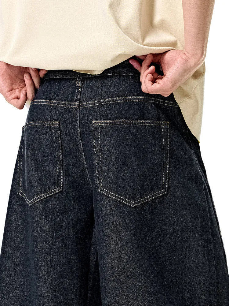 Men's wide leg denim trousers in original cow colour, showing mid waist and loose leg fit.