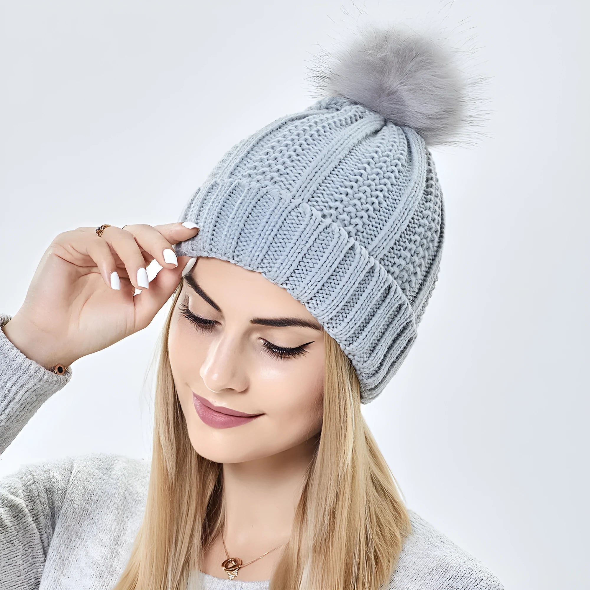 Women's knitted beanie hat with faux fur pom pom and satin lining in beige colour