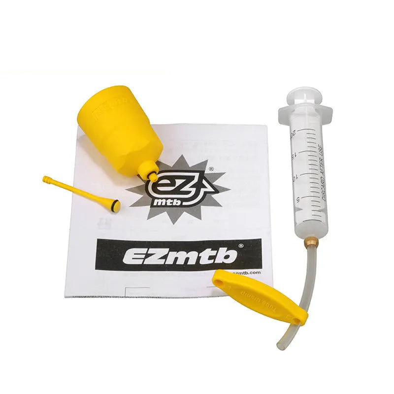 EZmtb bicycle hydraulic disc brake bleed kit with syringes, bottles, wrenches, and adapters on a workbench
