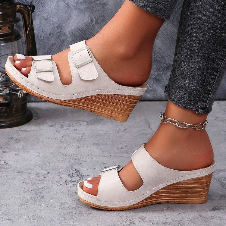 Women's creamy-white wedge beach slippers with a decorative belt buckle on the strap.