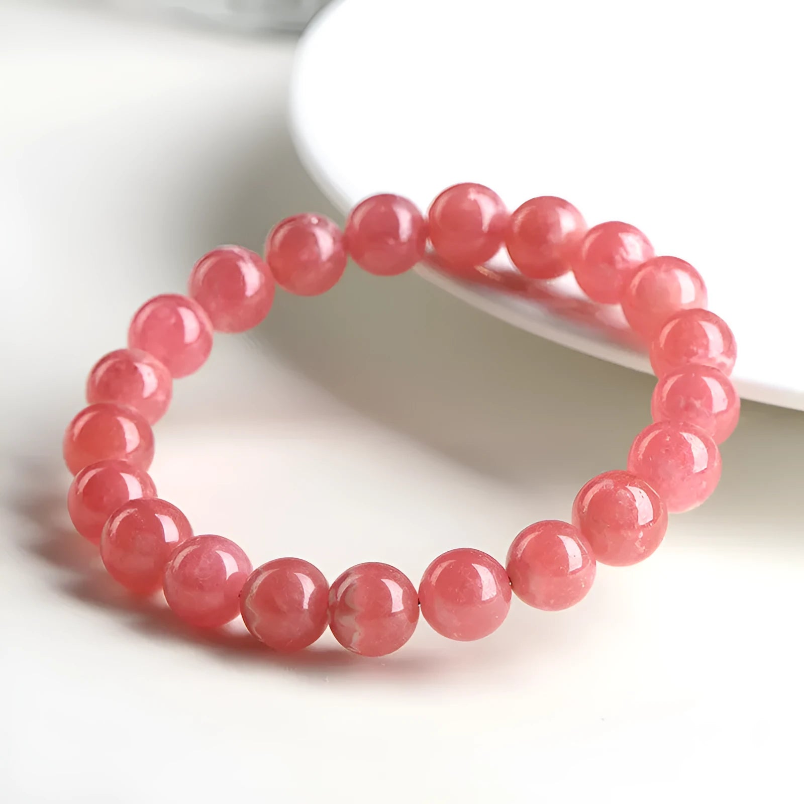 Women's red rhodochrosite crystal bracelet with geometric beads and Longevity Lock element.