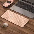 A slim white wireless keyboard and mouse set with a USB receiver on a desk.