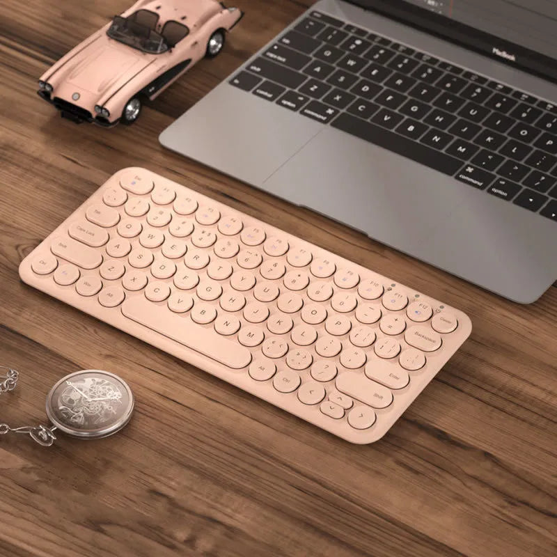 A slim white wireless keyboard and mouse set with a USB receiver on a desk.