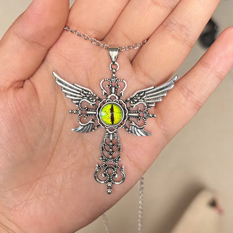 Close-up of a devil wings and cross geometric alloy pendant necklace on a chain.
