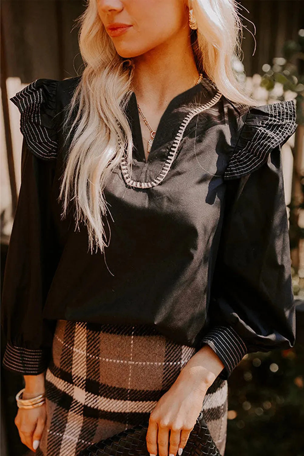 Black long sleeve blouse with V-neck, contrast stitching and ruffle sleeve detailing