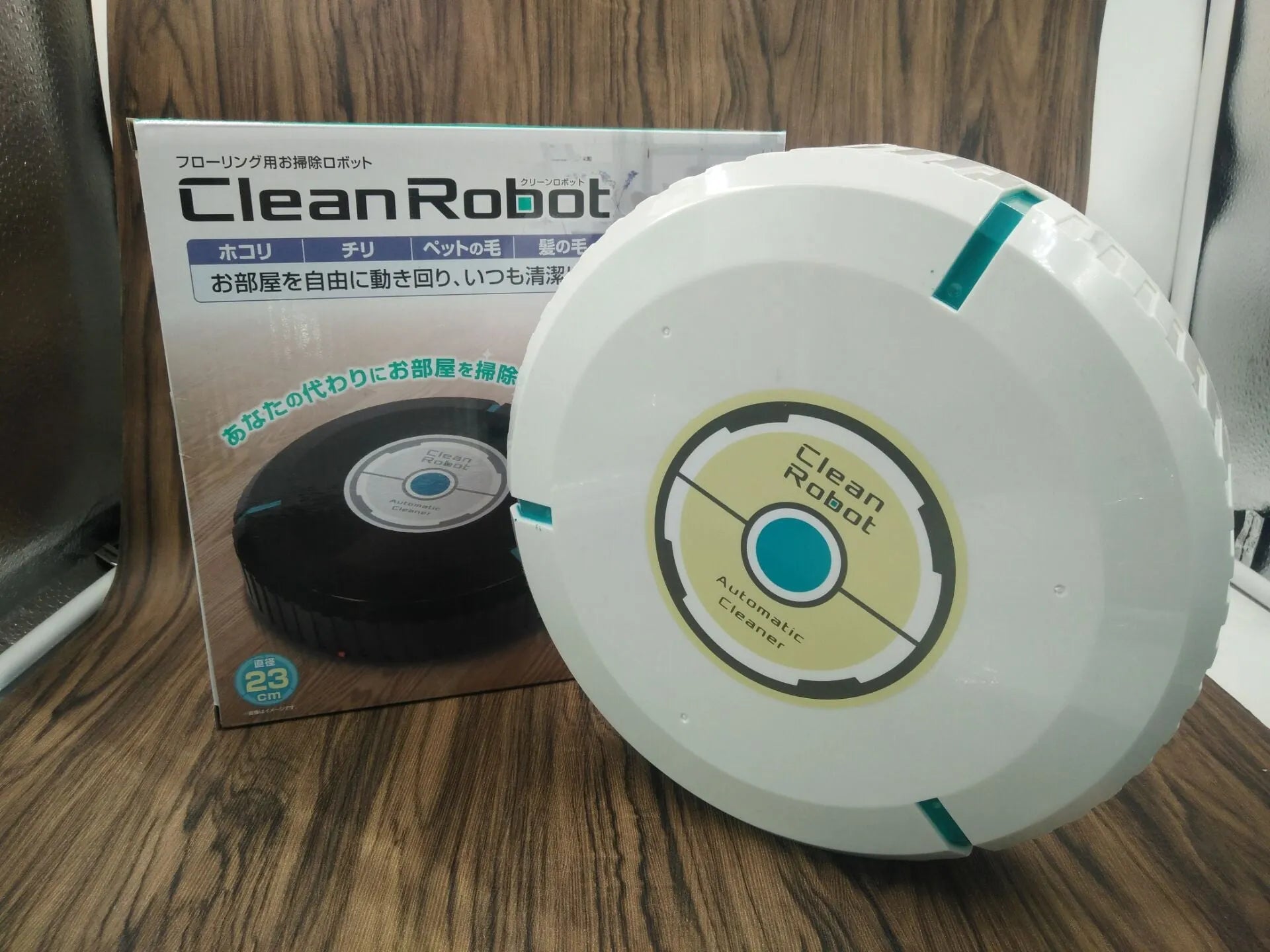 Black or white automatic sweeping robot vacuum cleaner on wooden floor