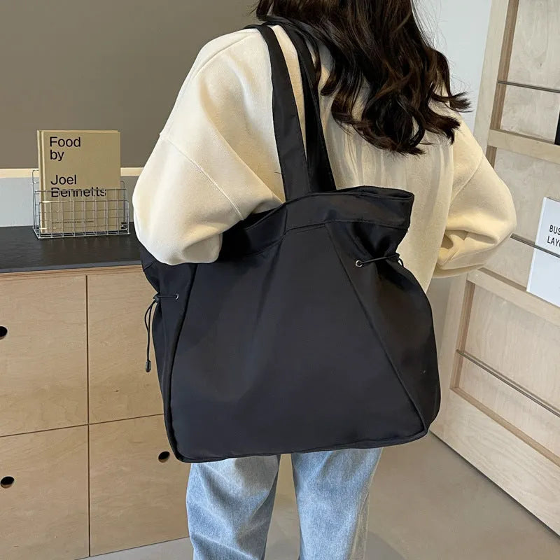 Soft Oxford cloth foldable tote bag shown in one of five colours: black, brown, dark grey, light grey, or purple.
