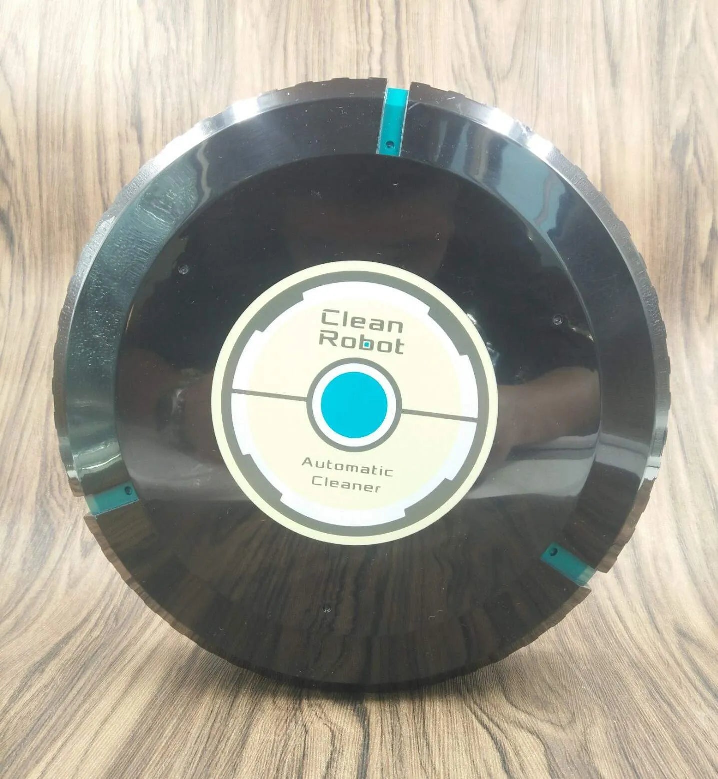 Black or white automatic sweeping robot vacuum cleaner on wooden floor
