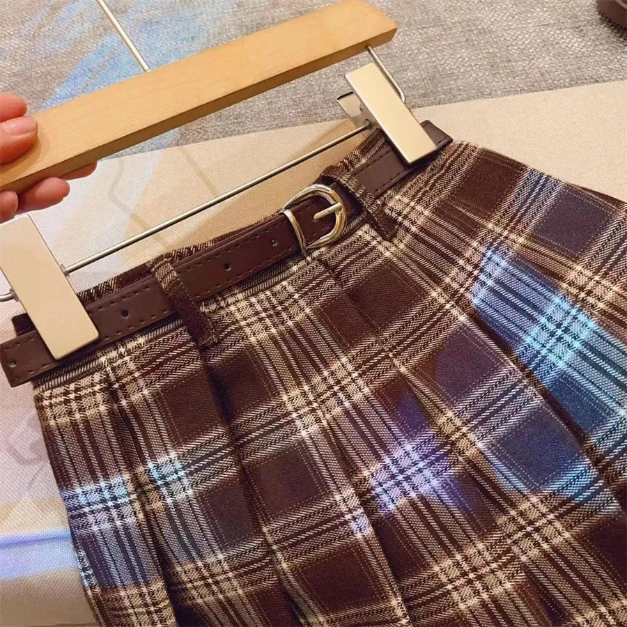 Girls plaid pleated A-line skirt in cotton-blend fabric on a hanger.