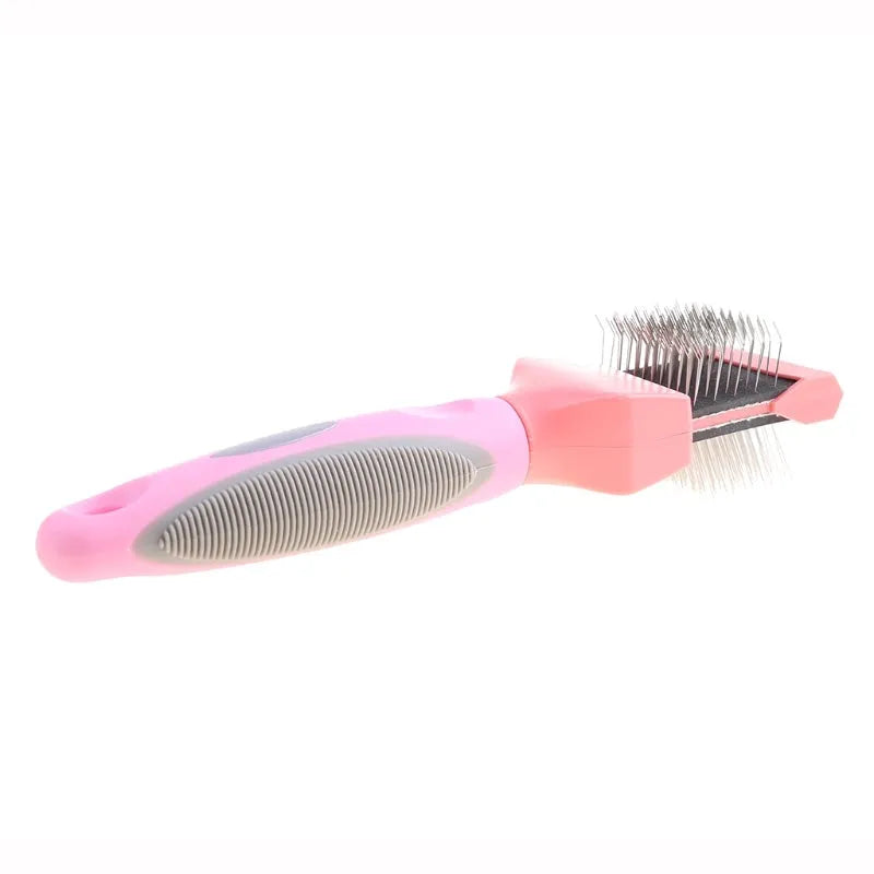 Blue double-sided pet brush with stainless steel pins next to a pink large version on a wooden surface.
