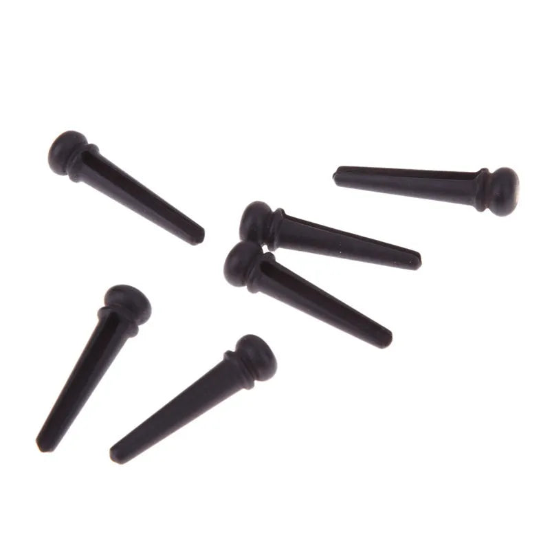 Six solid ebony guitar string nails with matte black finish for folk acoustic guitars