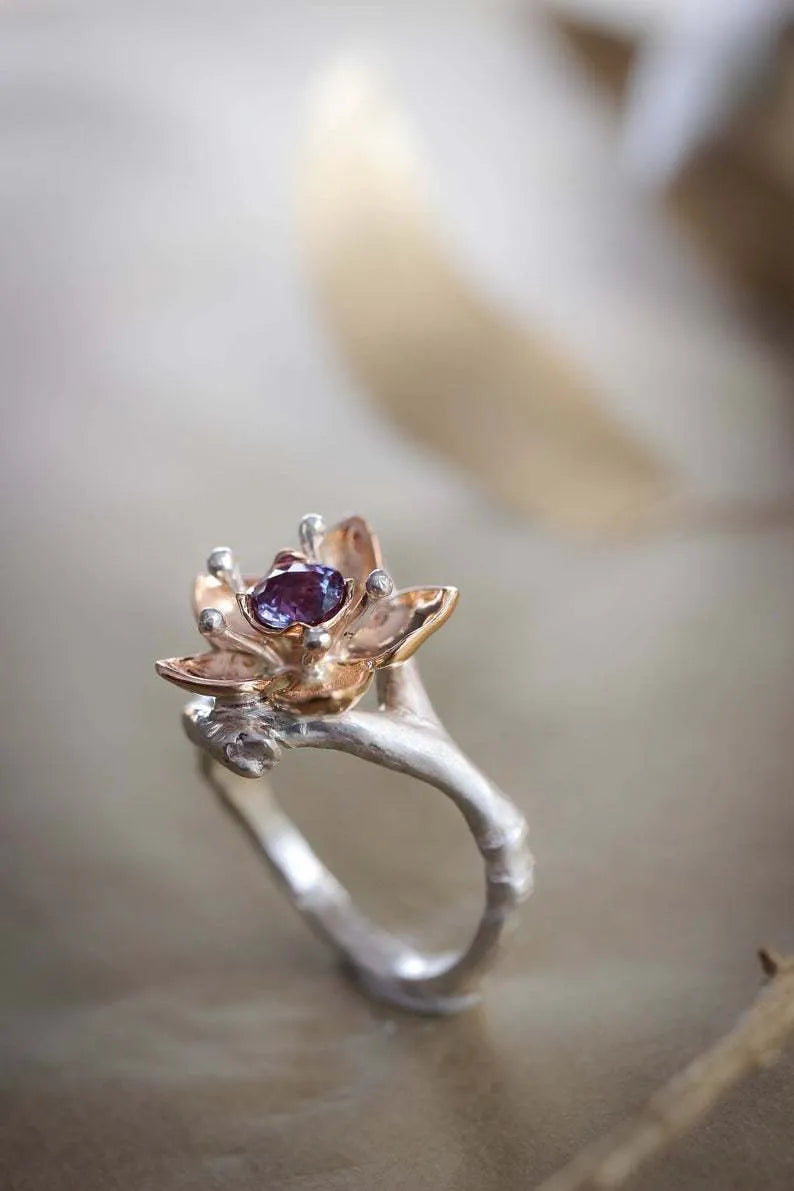 Two-tone silver alloy women's ring with floral geometric design on a flat surface