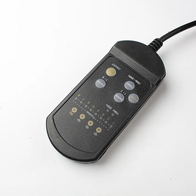 Black infrared heating massage mat with seat cushion on a chair, plugged into an AC outlet.