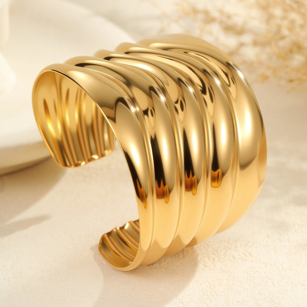Women's stainless steel bracelet with 18K gold plating featuring wave geometric design