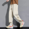 Men's loose fit ankle-tied sports pants in black with drawstring waist and elastic cuffs