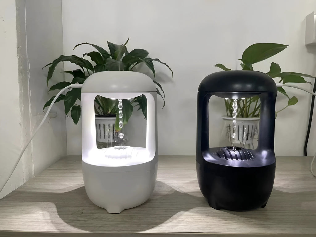 White anti-gravity humidifier on a table showing floating water droplets above its tank.
