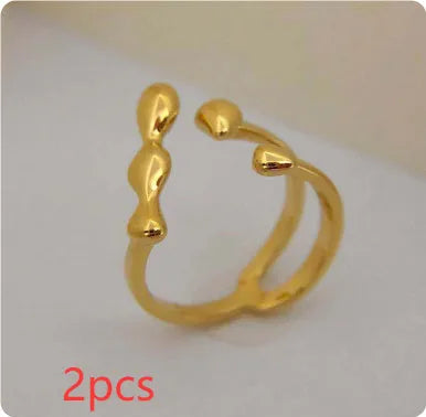 Brass opening ring with circle and sphere design in gold finish on finger