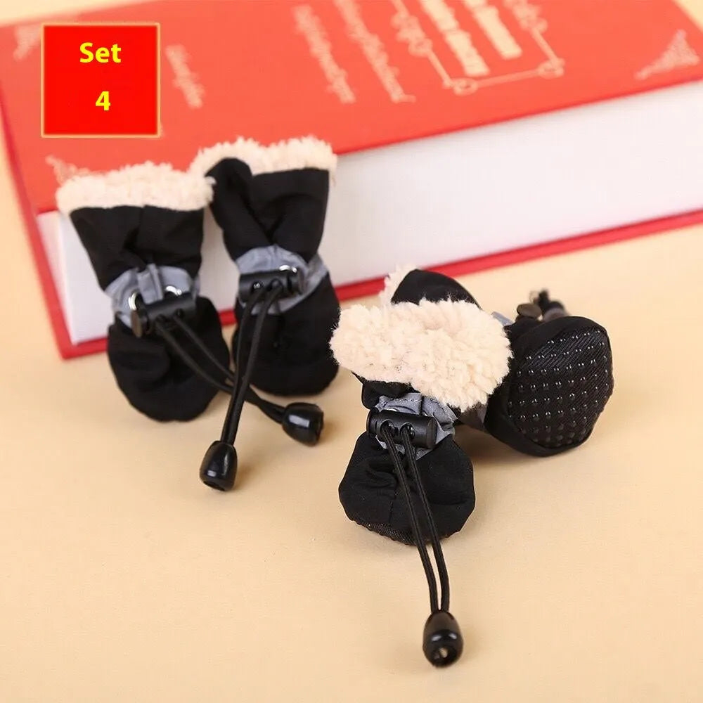 Set of four cloth dog shoes with soft soles in assorted colours on a neutral background