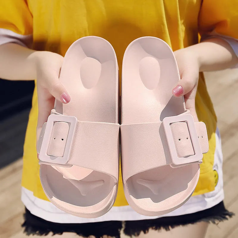 Women's grey blue flip flop slippers with a silver buckle on the strap and a textured EVA sole.