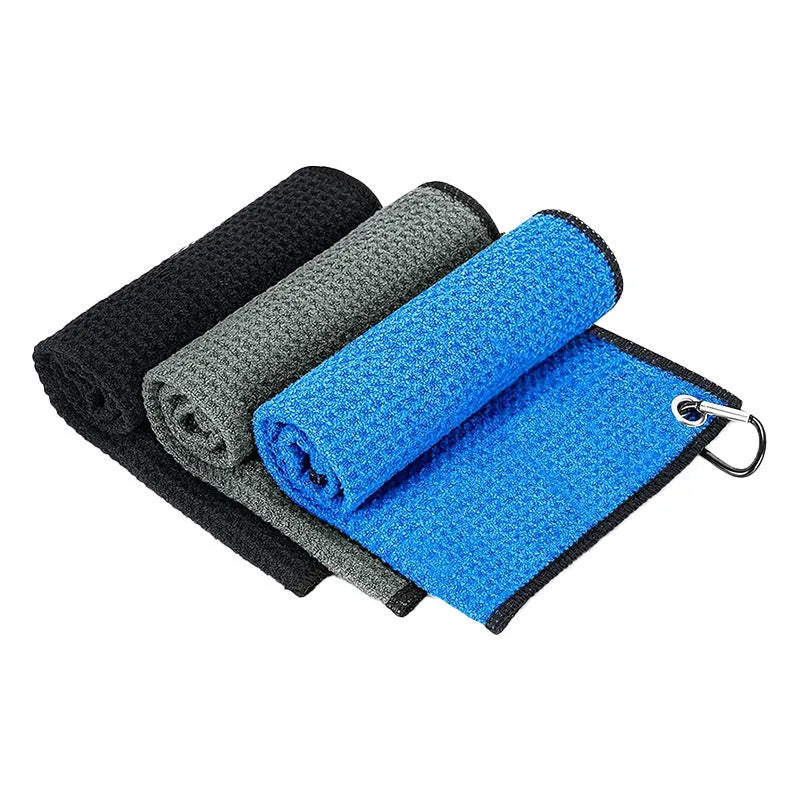 Waffle weave golf ball cleaning cloth in selected colour on a green.