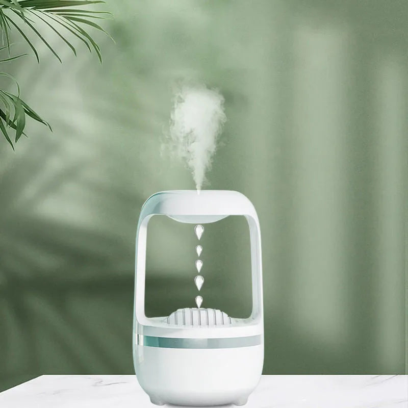 White anti-gravity humidifier on a table showing floating water droplets above its tank.