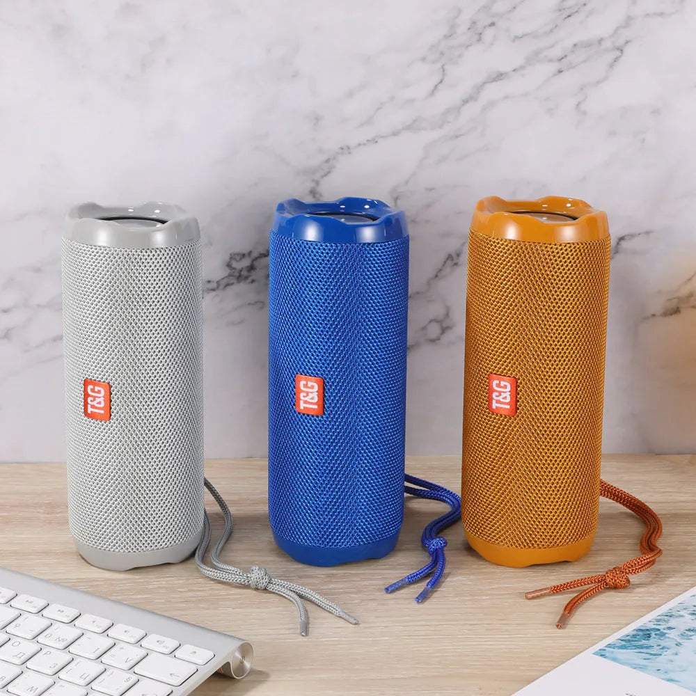 Fabric-covered portable Bluetooth speaker with card holder slots, shown in multiple colour options.