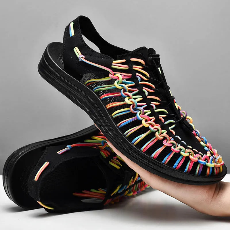 Closed-toe woven sandals with an elastic drawstring tie around the ankle in a rainbow colour pattern.