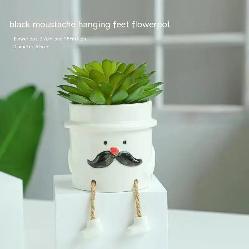 Ceramic cartoon-style hanging foot flowerpot for succulent plants on a desktop.