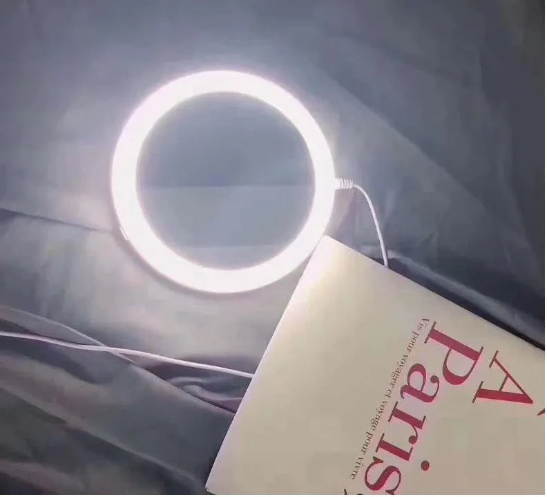 White foldable LED vanity mirror with storage tray and USB cable.