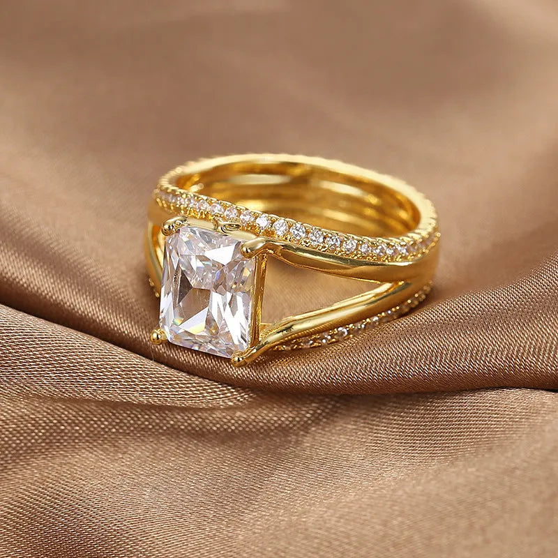 Gold geometric women's ring with a square zircon stone on a copper band.
