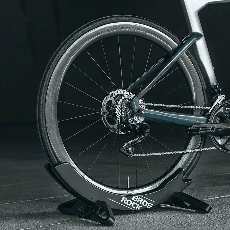 Black and green ABS plastic bicycle parking rack holder with fixed wall mounting bracket.