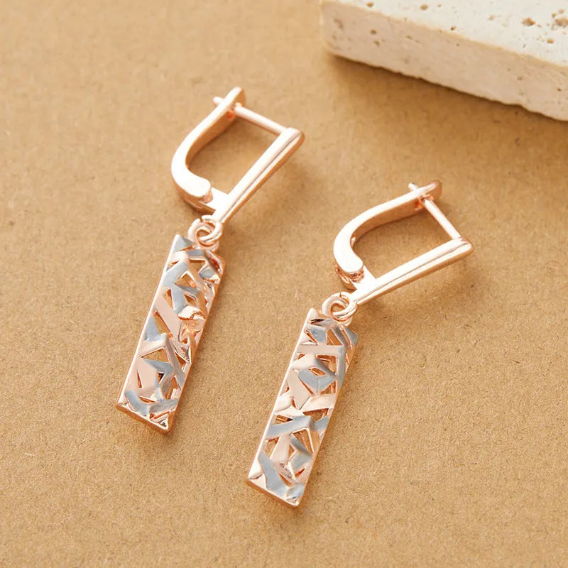 A pair of women's rectangular hollow stud earrings with a two-tone metal finish.