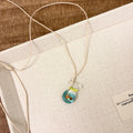 Women's joker charm necklace with coloured glaze pendant on a cotton and linen clavicle chain.