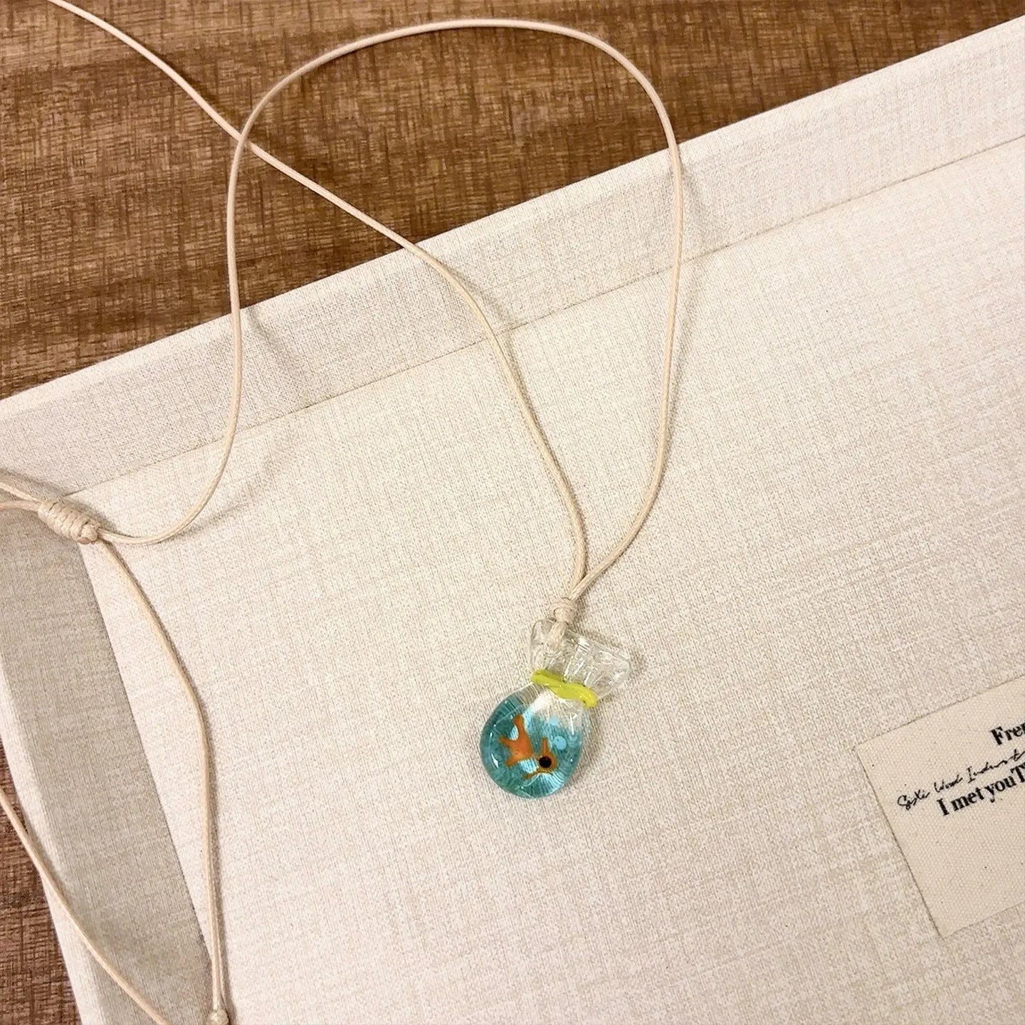 Women's joker charm necklace with coloured glaze pendant on a cotton and linen clavicle chain.