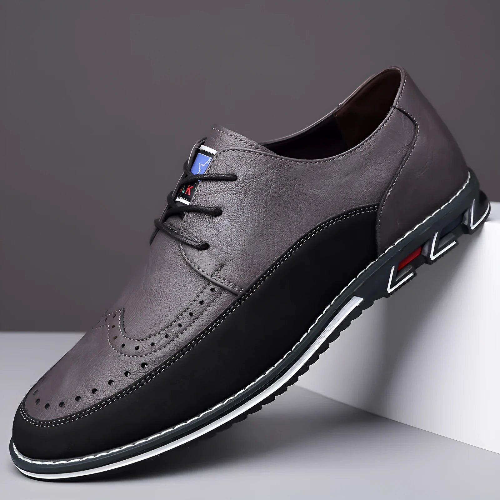 Men's black leather-toe casual shoes with a fabric upper and rubber sole on a plain background.