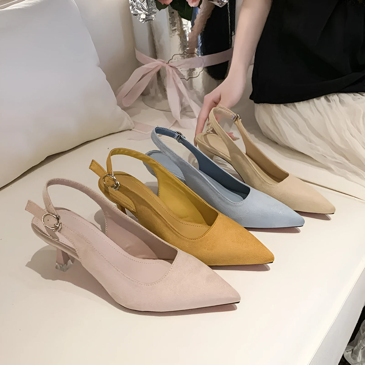 A pair of women's apricot suede stiletto heels with a pointed toe and thin high heel.
