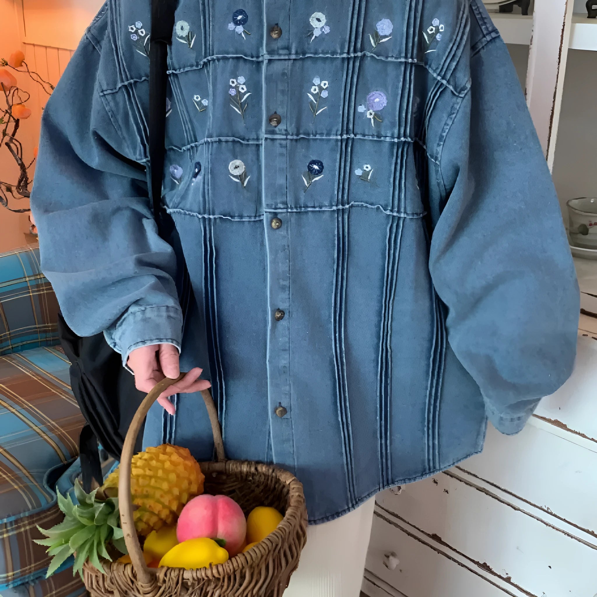 Washed blue denim shirt with small floral pleated detailing and button front closure