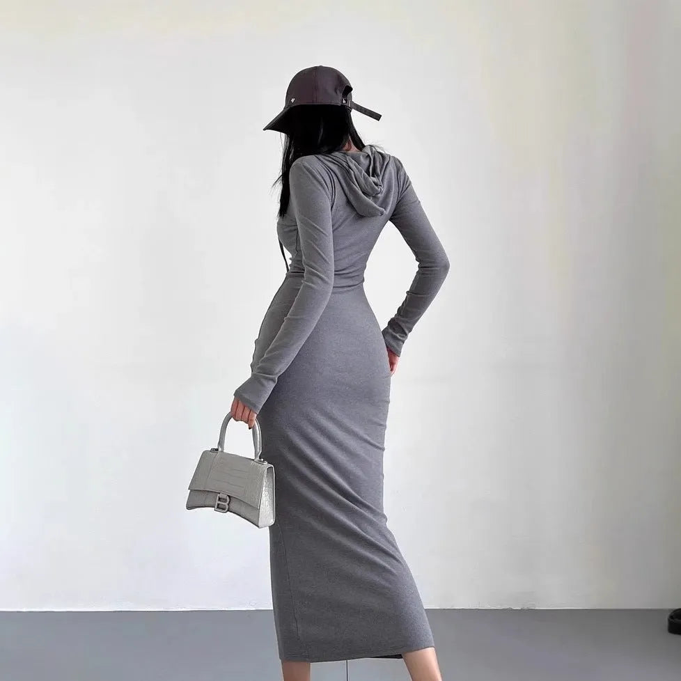 A woman modelling a grey hooded long sleeve sheath dress with a high waist.