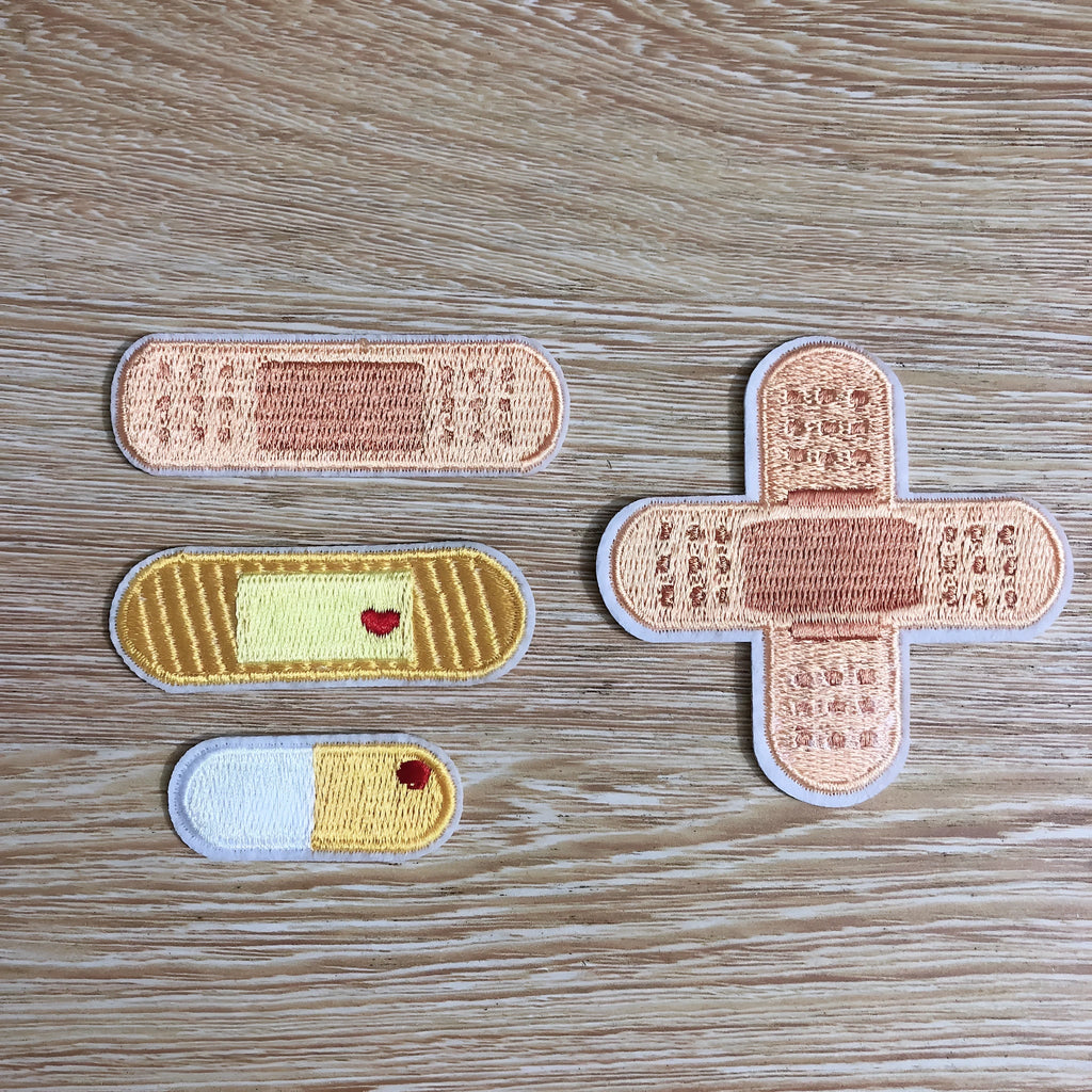 Ten computer-embroidered patch badges with adhesive backing for clothing decoration.