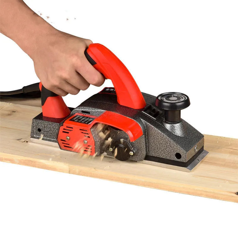 Red electric wood planer tool with aluminum shell showing 82mm planing width measurement