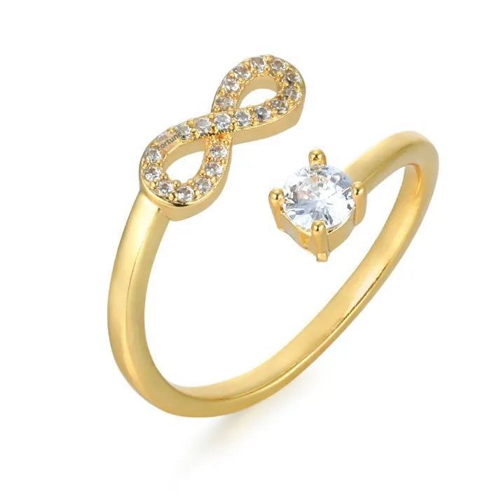 Geometric open ring with a single inlaid zircon letter on a metal band, shown in gold, rose gold, and silver finishes.